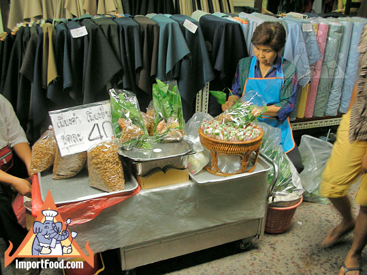 Bangkok Vendor Prepares Miang Kham on a Busy Pathway in the Fabric District