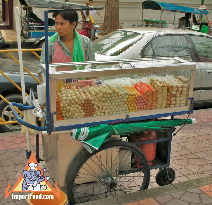 Thai Street Vendor Offers Assorted Deep-Fried Meatballs from a Push Cart