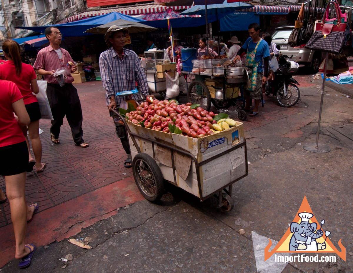 Pushing a Fruit Cart At Busy Thai Market